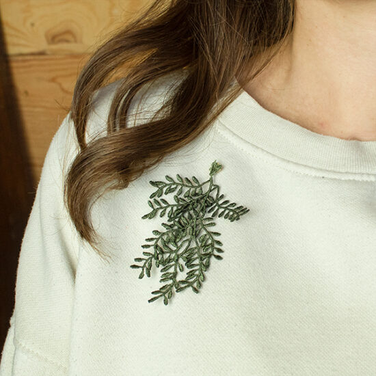Broche met geborduurde olijftak op model