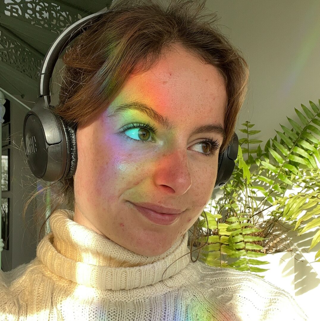 person with rainbow reflects on her