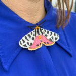 Tiger moth embroidered brooch on blue blouse